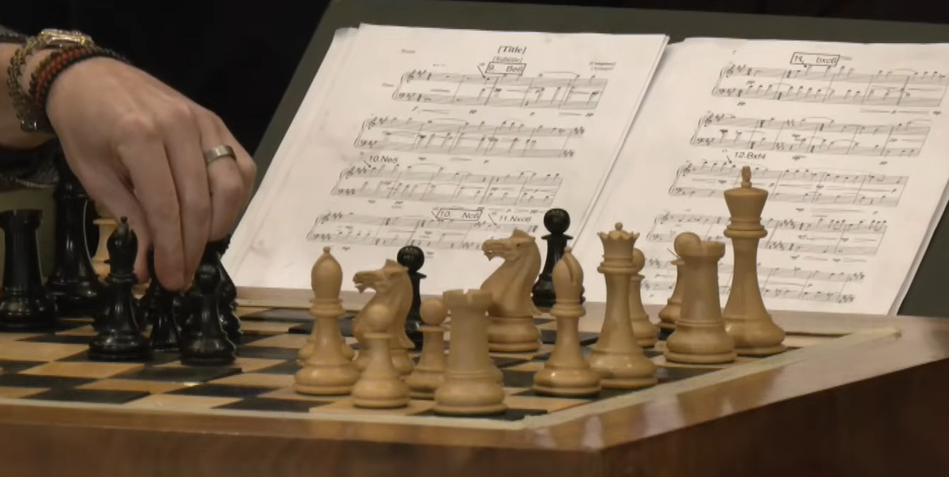 Zetten van de gecomponeerde schaakpartij door Yudasin voor de schaakpiano van Guido van der Werve